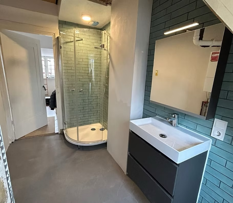 Badkamer met nieuwe wastafel, spiegel en douchecabine
